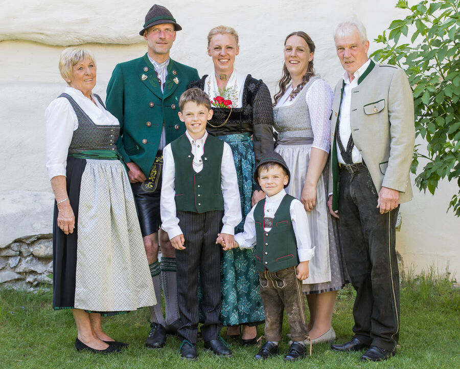 Die Familie Anker-Feistl in Tiroler Tracht vor dem Hof