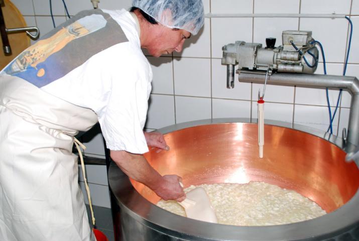 Käser rührt die Milch im großen Kessel